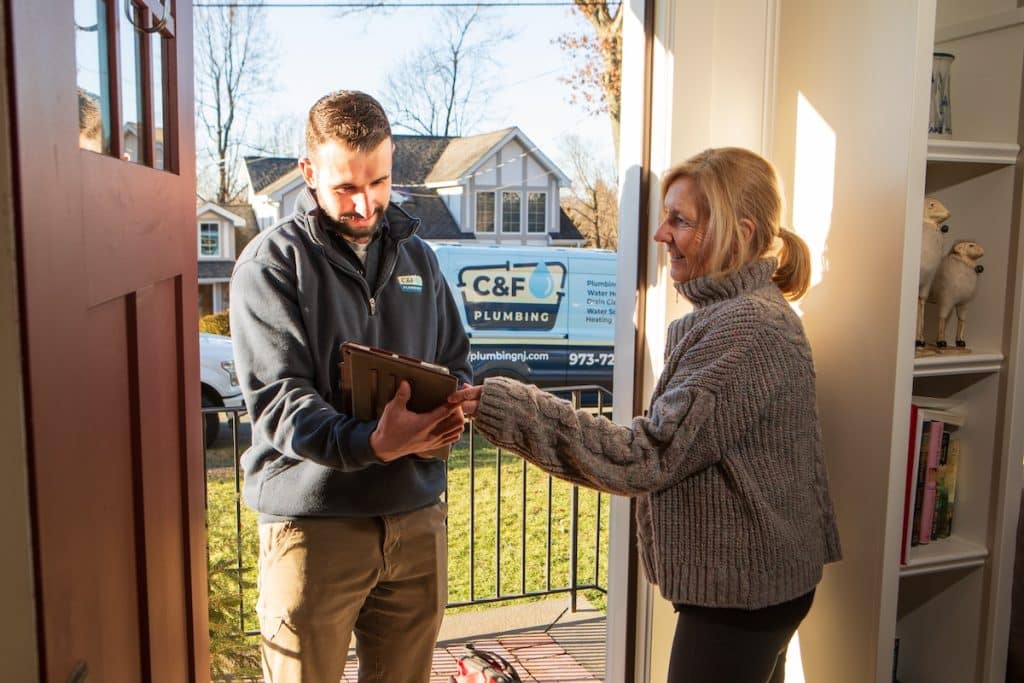 C&F Plumbing technician talking to the client for a residential and commercial plumbing service in Sparta, NJ.